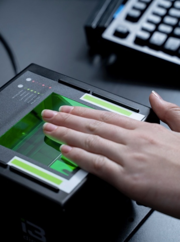 Person placing their hand on a fingerprinting device
