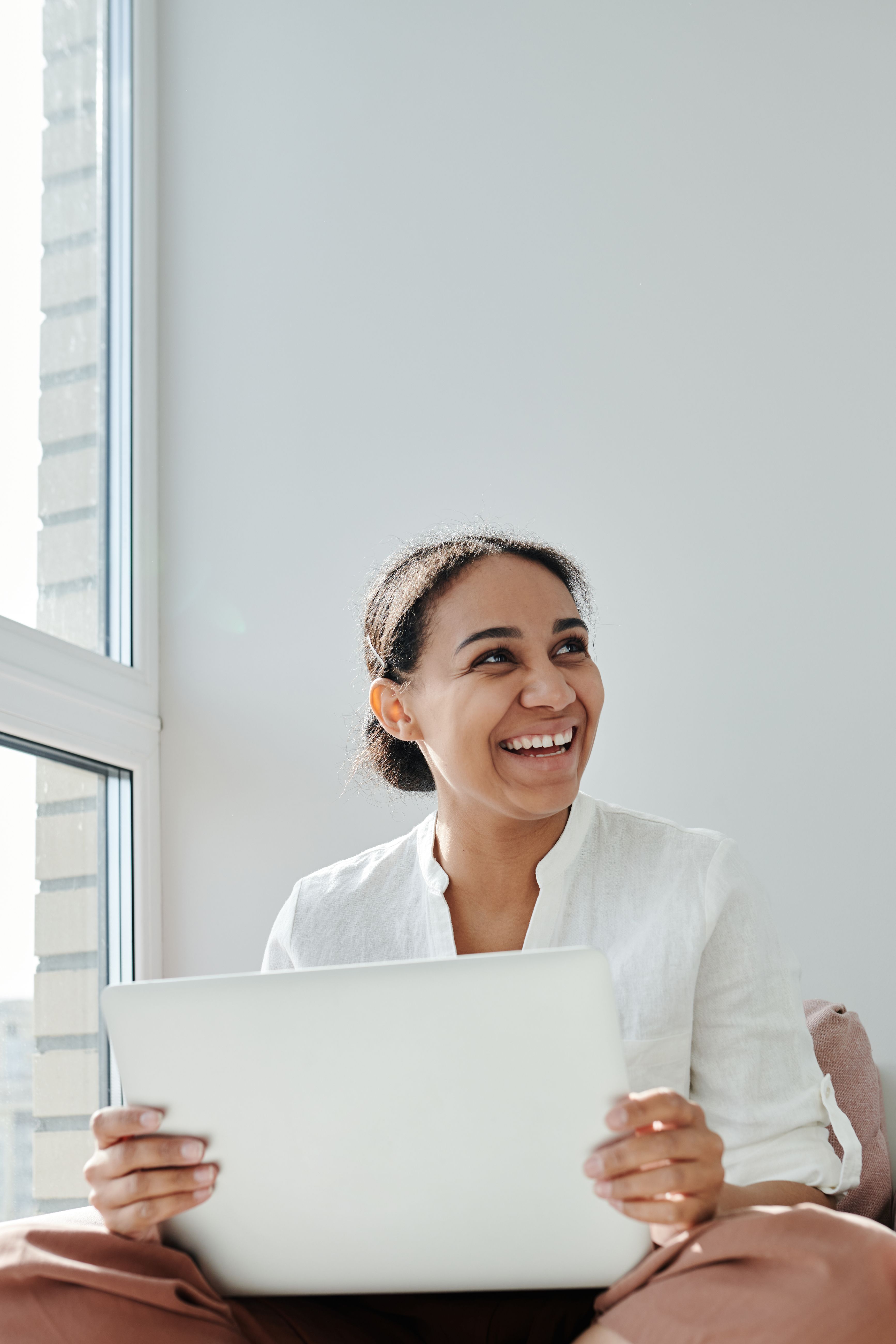 A person smiling while using a laptop at home