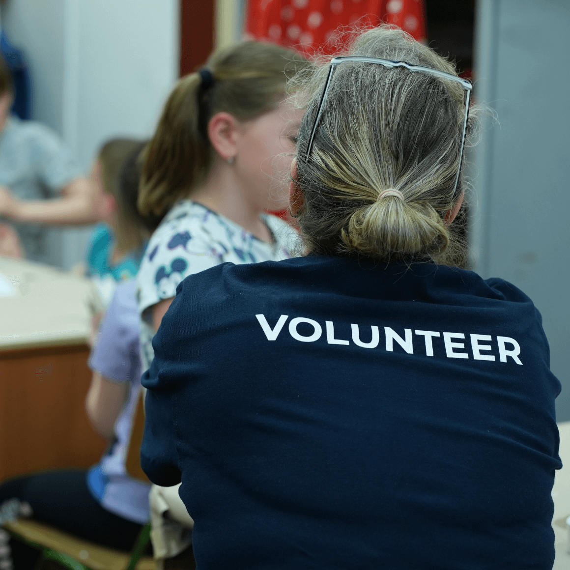 School volunteer interacting with child in classroom